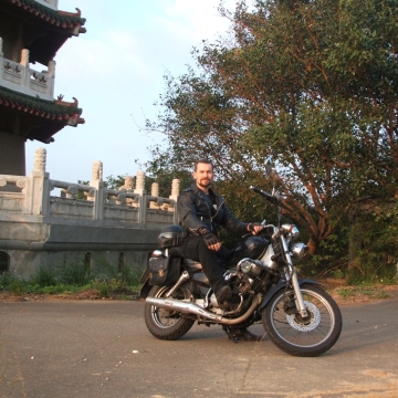 Rick Carlile on motorcycle outside deserted pagoda in Hsinchu